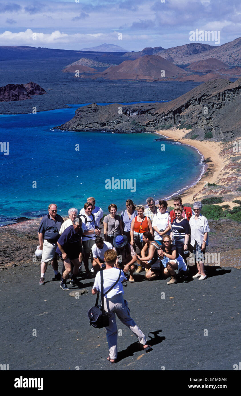 Los turistas posan para la foto, encima de la Roca Pináculo, Bartolomé, Islas Galápagos, Ecuador, América del Sur. Foto de stock