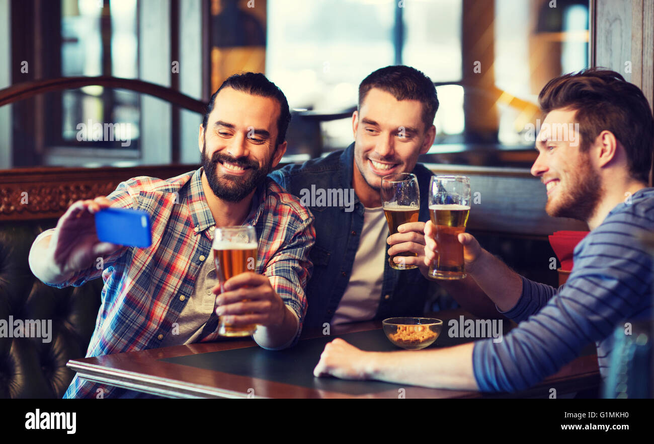 Amigos tomando selfie y bebiendo cerveza en el bar Fotografía de stock -  Alamy
