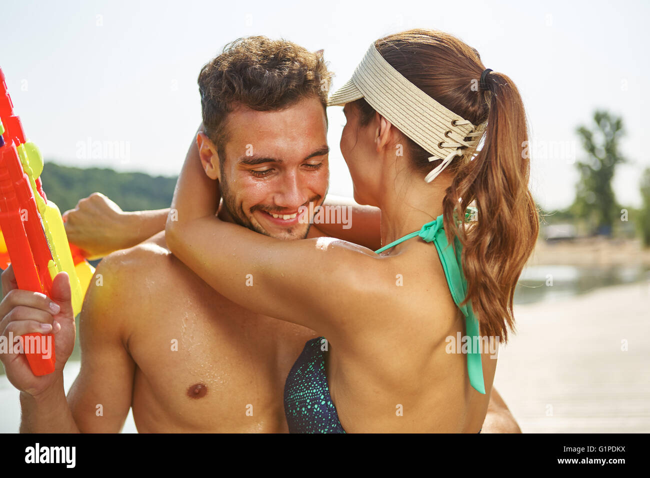 Pareja en amor abrazando a un lago en verano Foto de stock