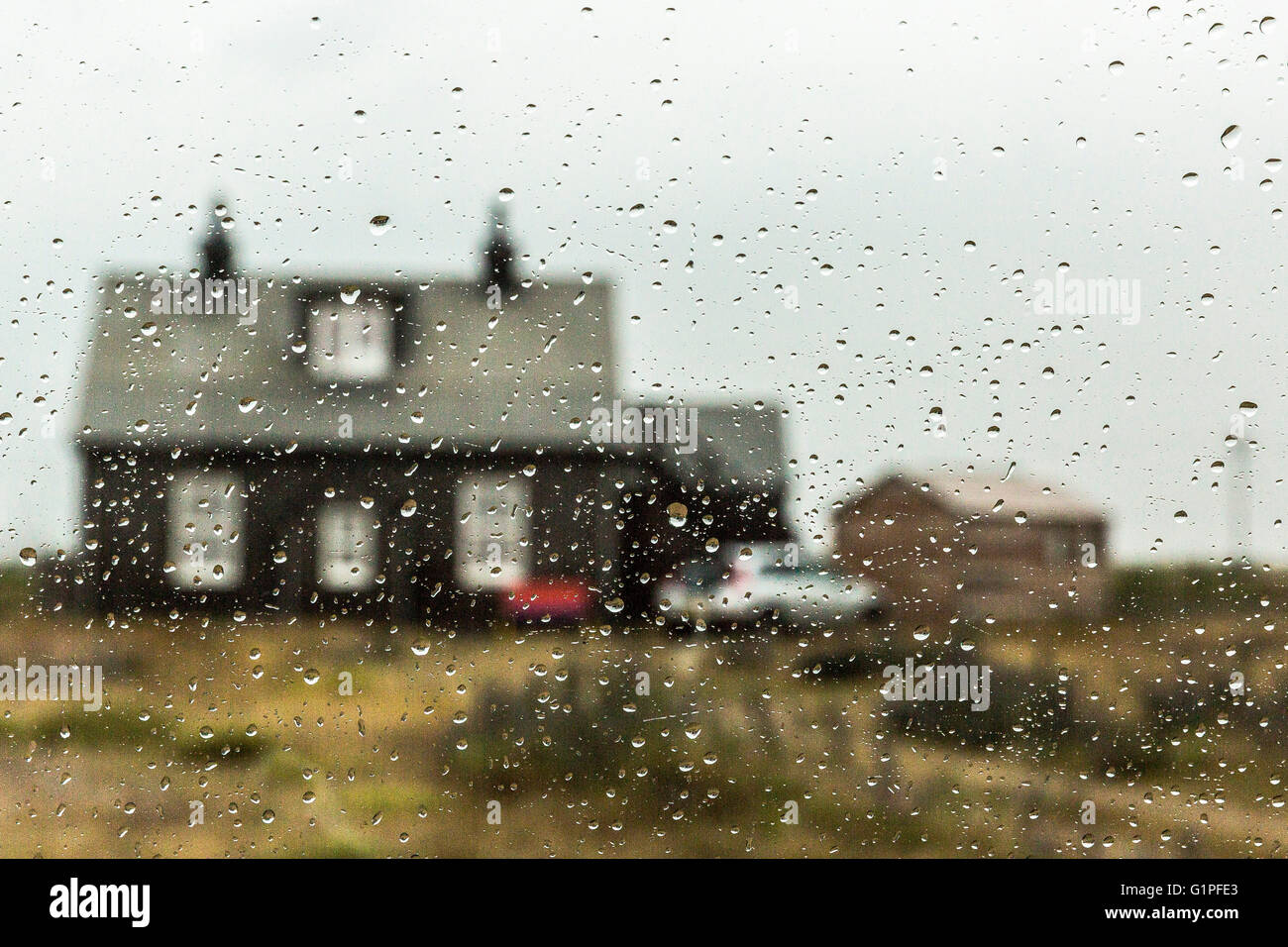 Casa vistos a través de las gotas de cristal de coche mojado. Península de Dungeness, Romney Marsh, Kent, UK Foto de stock