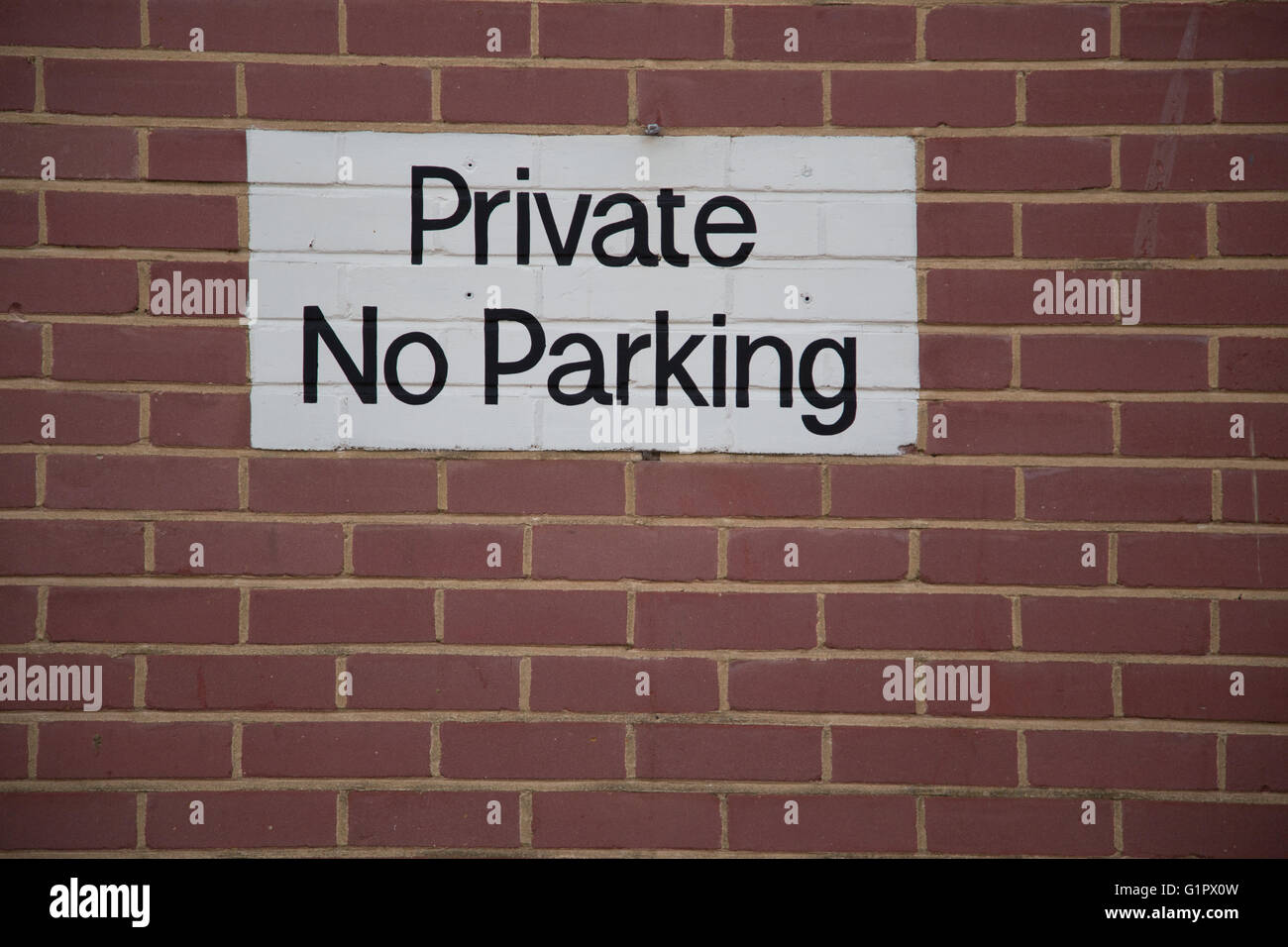 No hay aparcamiento privado pintado un cartel en una pared de ladrillo con una gran área de copia Foto de stock