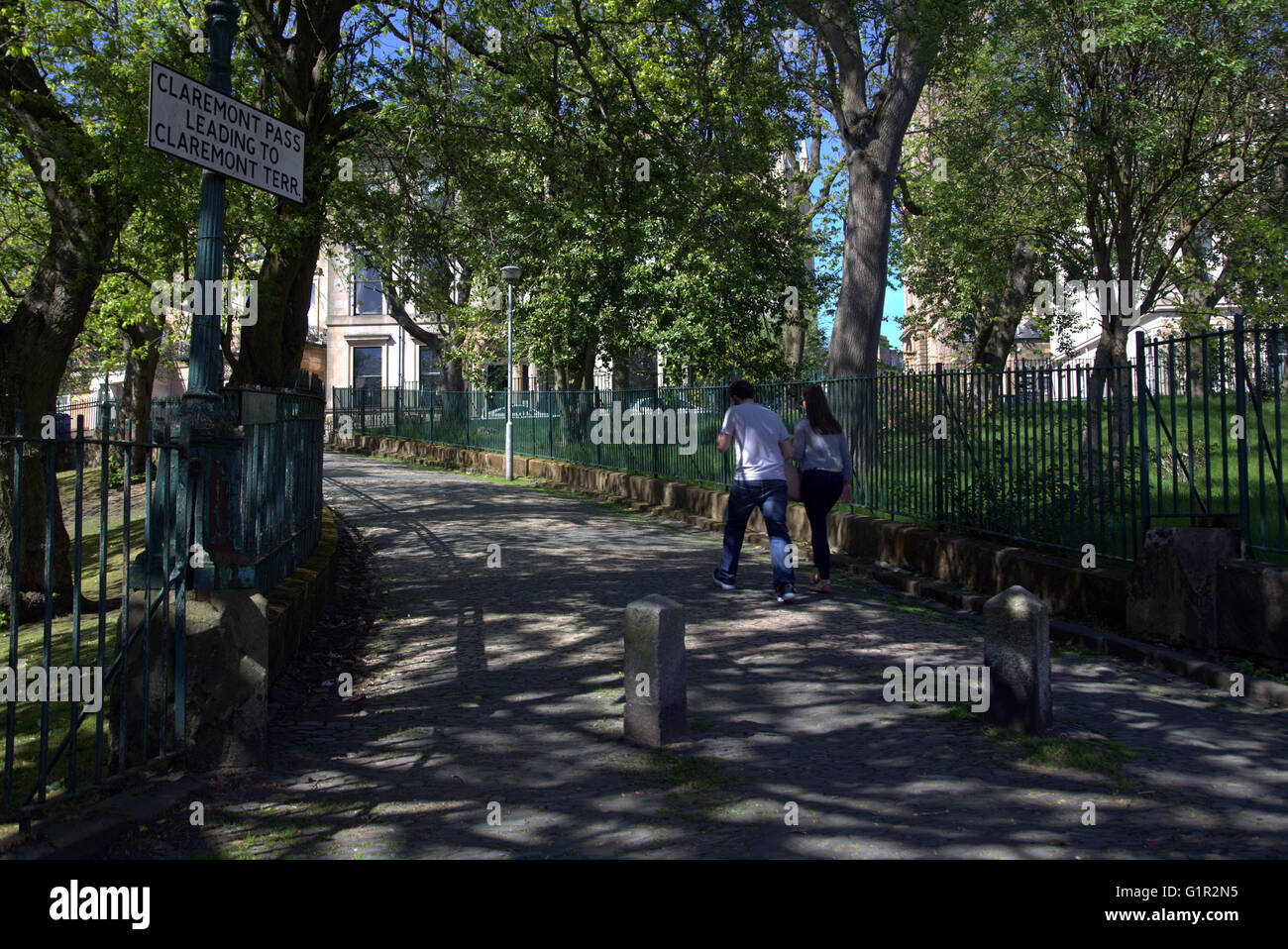 Pareja joven hombre y mujer caminando en la pintoresca localidad de Claremont pasar,Park Circus, Glasgow, Escocia, Reino Unido. Foto de stock