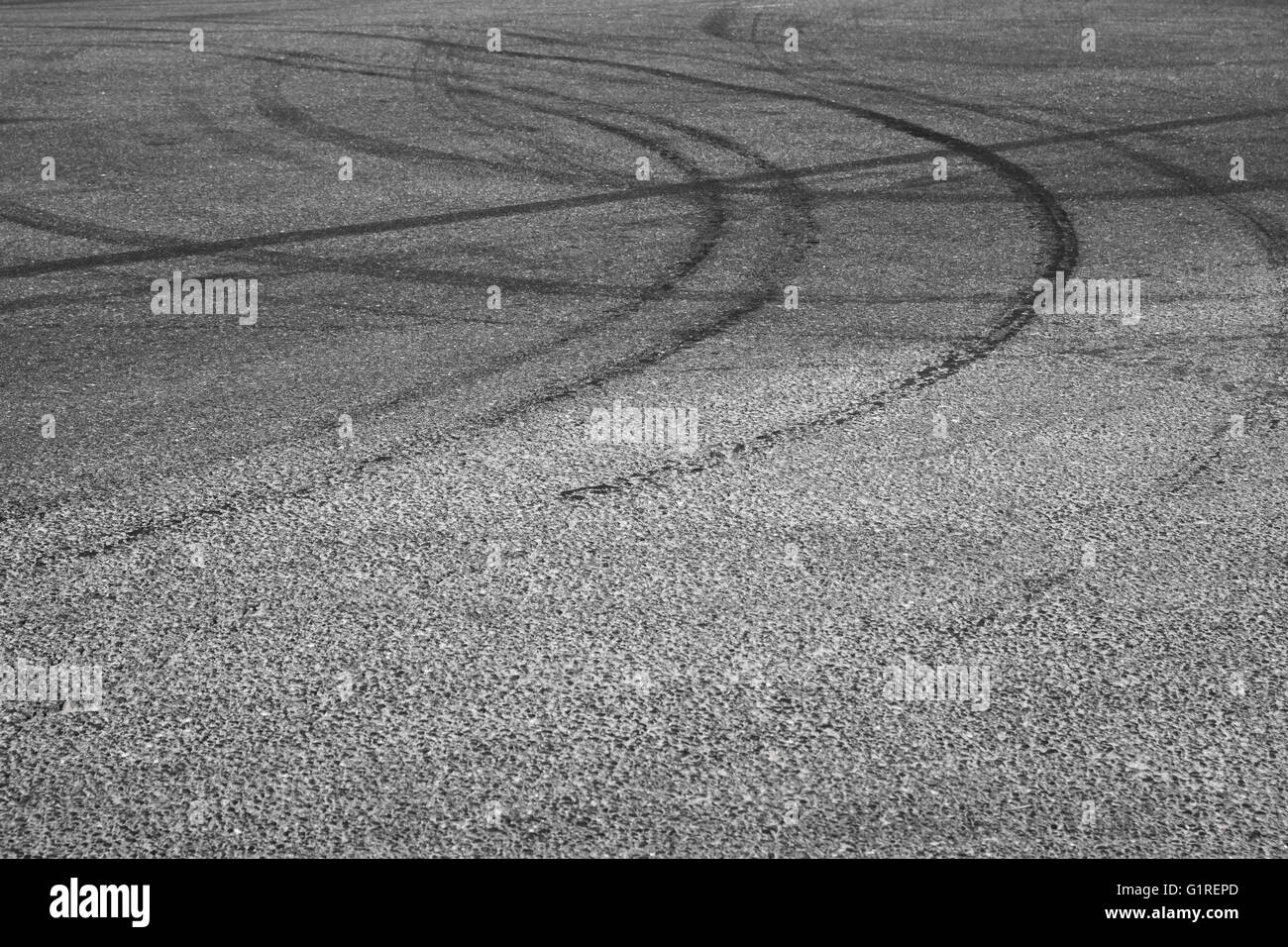 Resumen El transporte de fondo oscuro con las huellas de los neumáticos sobre el asfalto gris Foto de stock