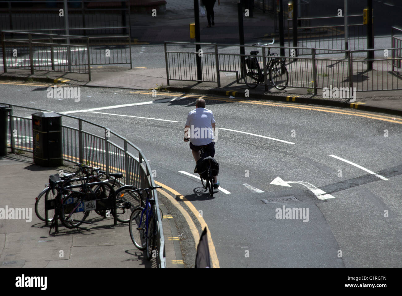 Un varón de mediana edad ciclista en bicicleta un redondeo de la esquina de la ciudad vista desde arriba, Glasgow, Escocia, Reino Unido. Foto de stock