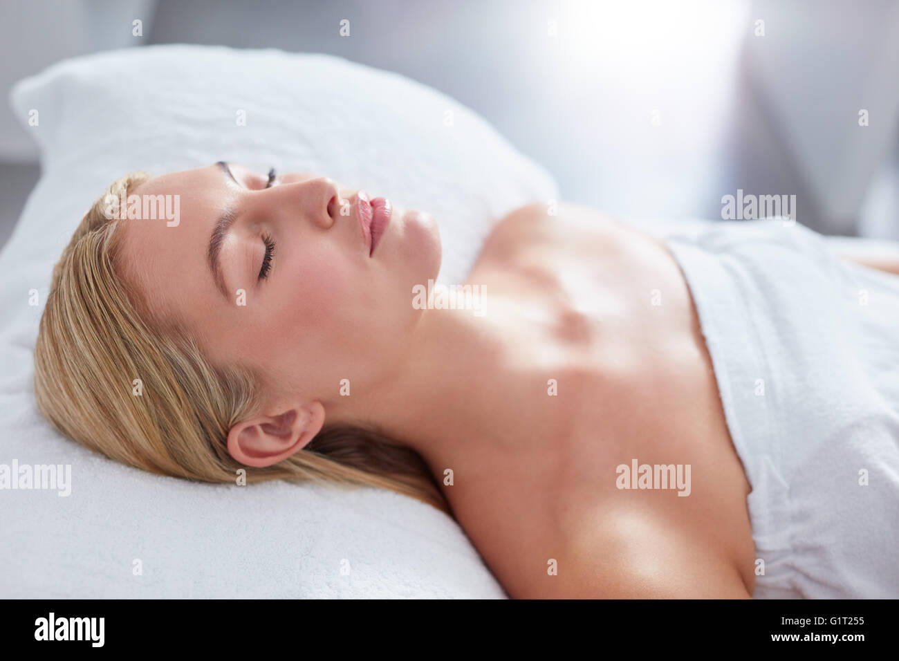 Cerca de mujer atractiva en dayspa. Ella está acostada sobre la mesa de masajes. Concepto de belleza y salud. Foto de stock