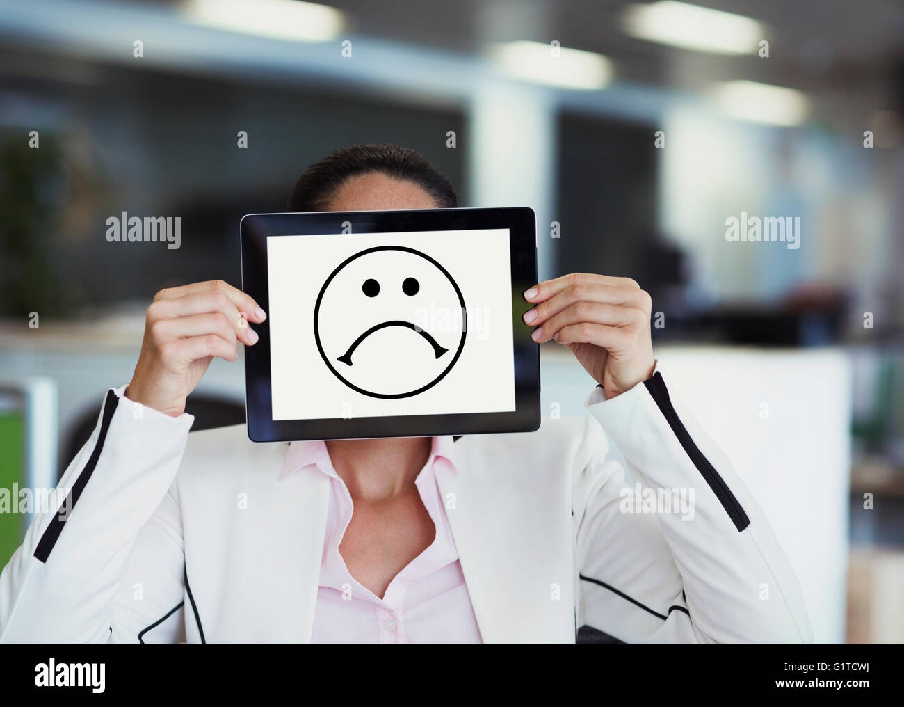 Retrato de mujer de negocios que cubren la cara con tableta digital en Office Foto de stock