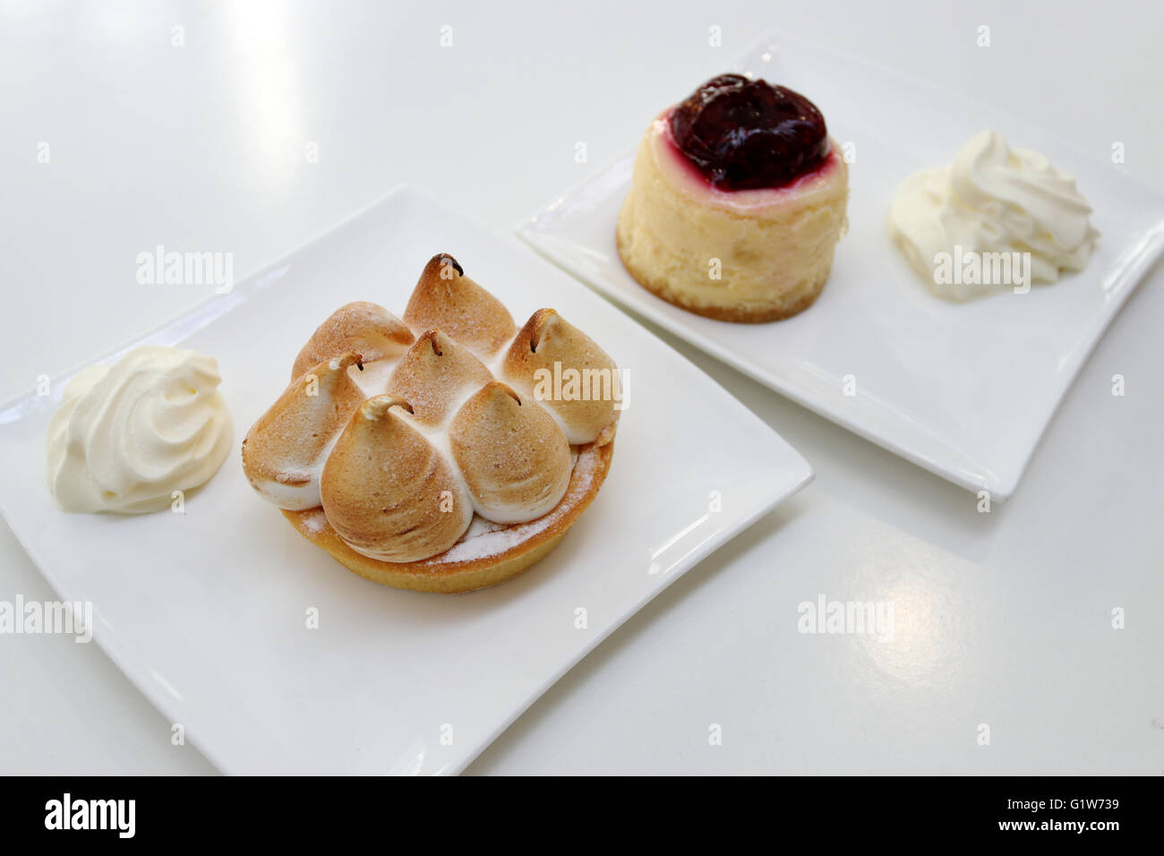 Merengue de limón y strawberry cheesecake sobre placa blanca. Foto de stock