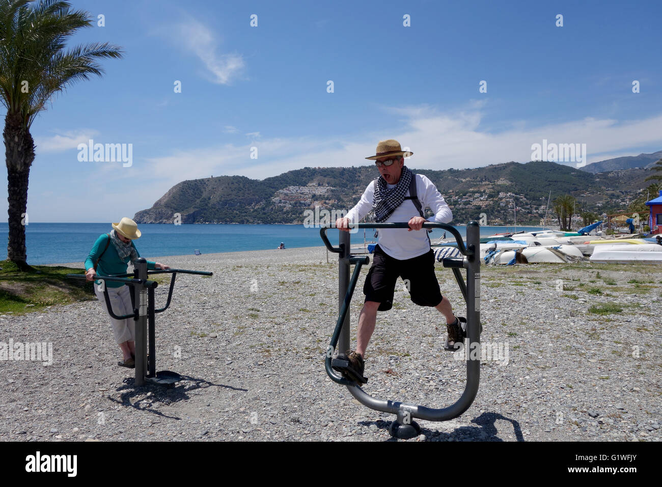 Personas que utilizan máquinas de ejercicio para mantenerse en forma pública en playa La Herradura en España Europa Foto de stock
