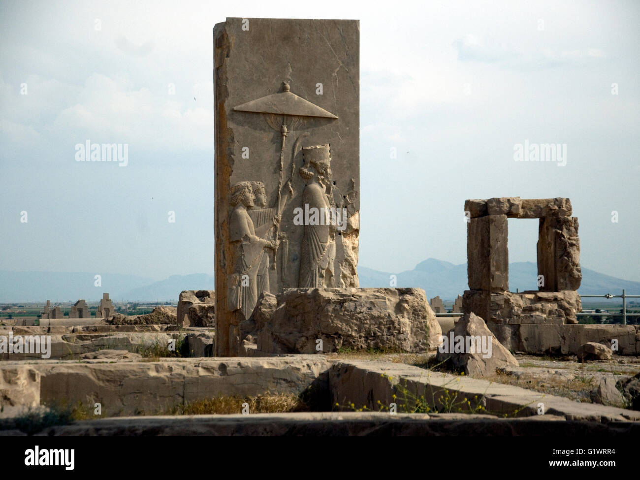 En Irán, las grandes ruinas de un complejo de palacio, Persépolis, una gran piedra tallada demuestra vívidamente gobernante y gobernados, quizás un emperador y asistentes. Que precisamente no es clara Foto de stock