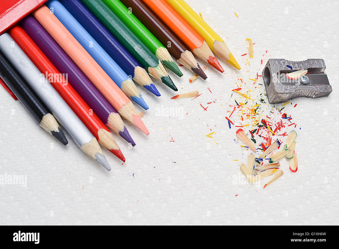Closeup en coloridos lápices para dibujar y el afilador en una toalla de papel blanco Foto de stock