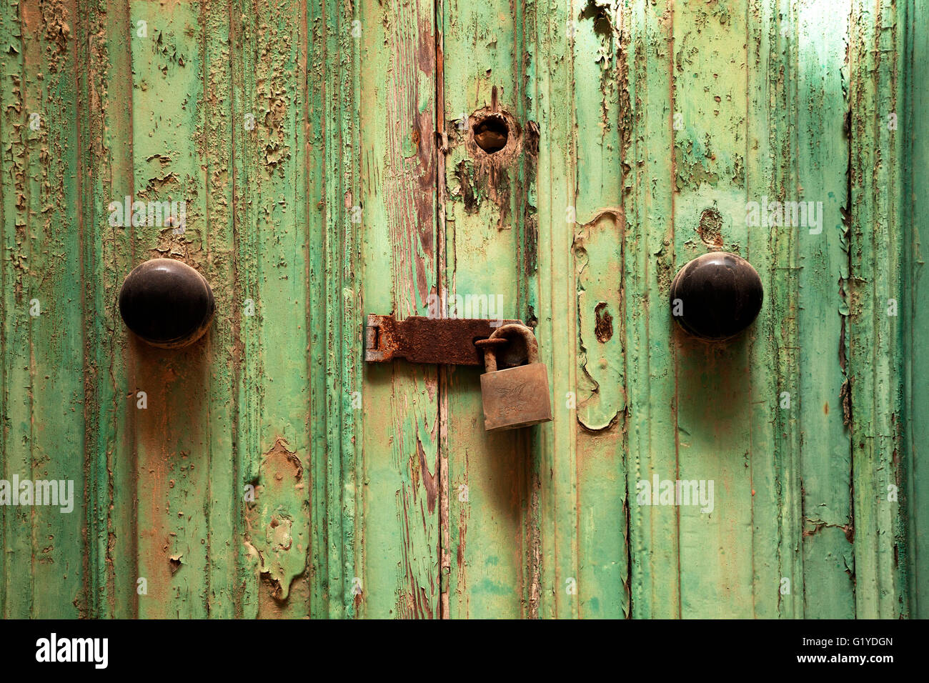 Rusty la cerradura de la puerta con cerradura en la puerta de madera desgastada con pintura verde, Valletta, Malta Foto de stock