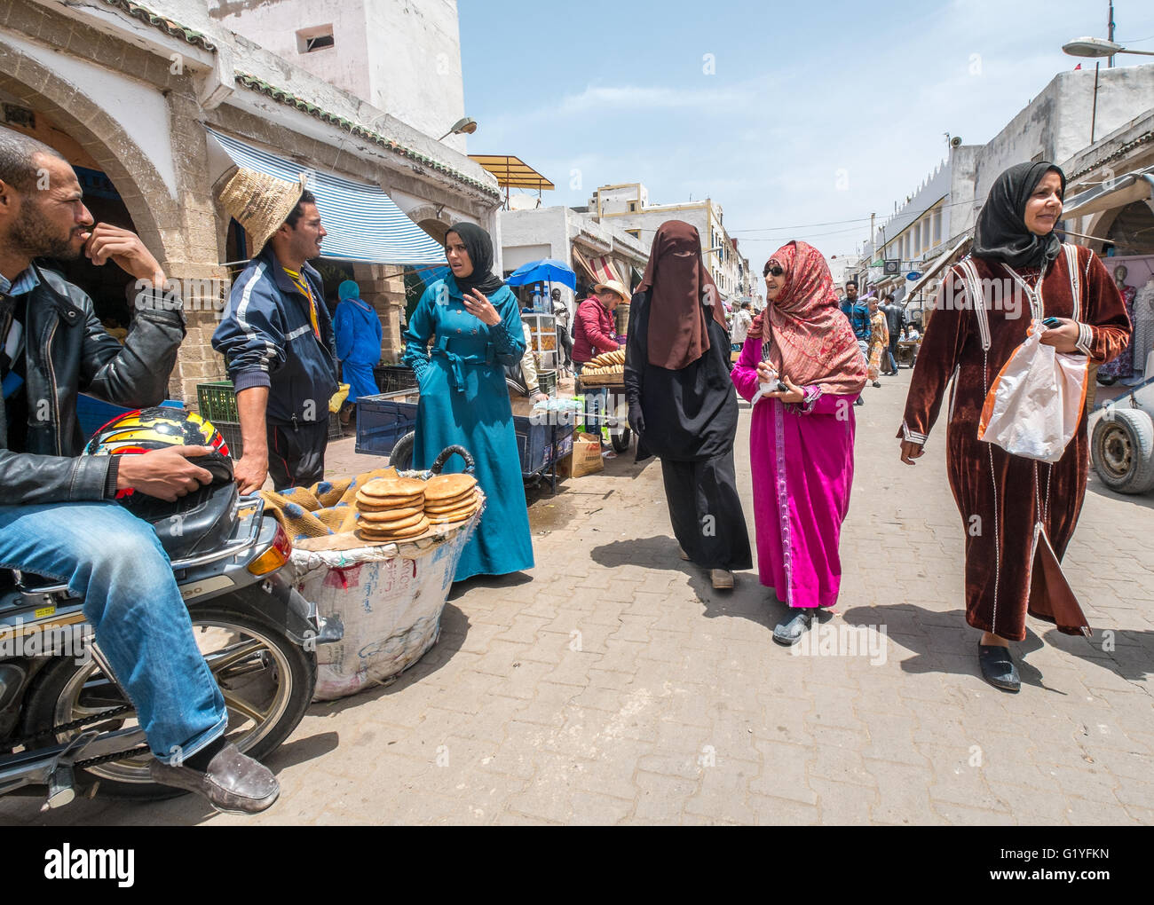 Los marroquíes en sus quehaceres cotidianos en la bulliciosa medina (ciudad vieja) de Essaouira, Marruecos Foto de stock
