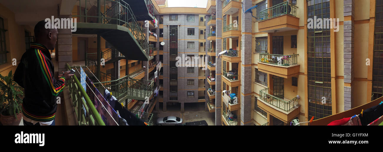 Un hombre que mira a través de un bloque de apartamentos en Nairobi, Kenia Foto de stock