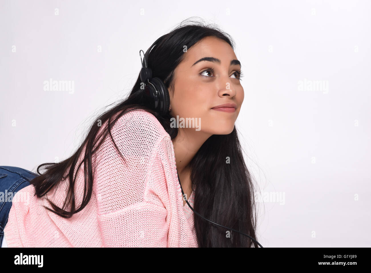 Hermosa joven mujer escuchando música. Fondo blanco aisladas. Foto de stock