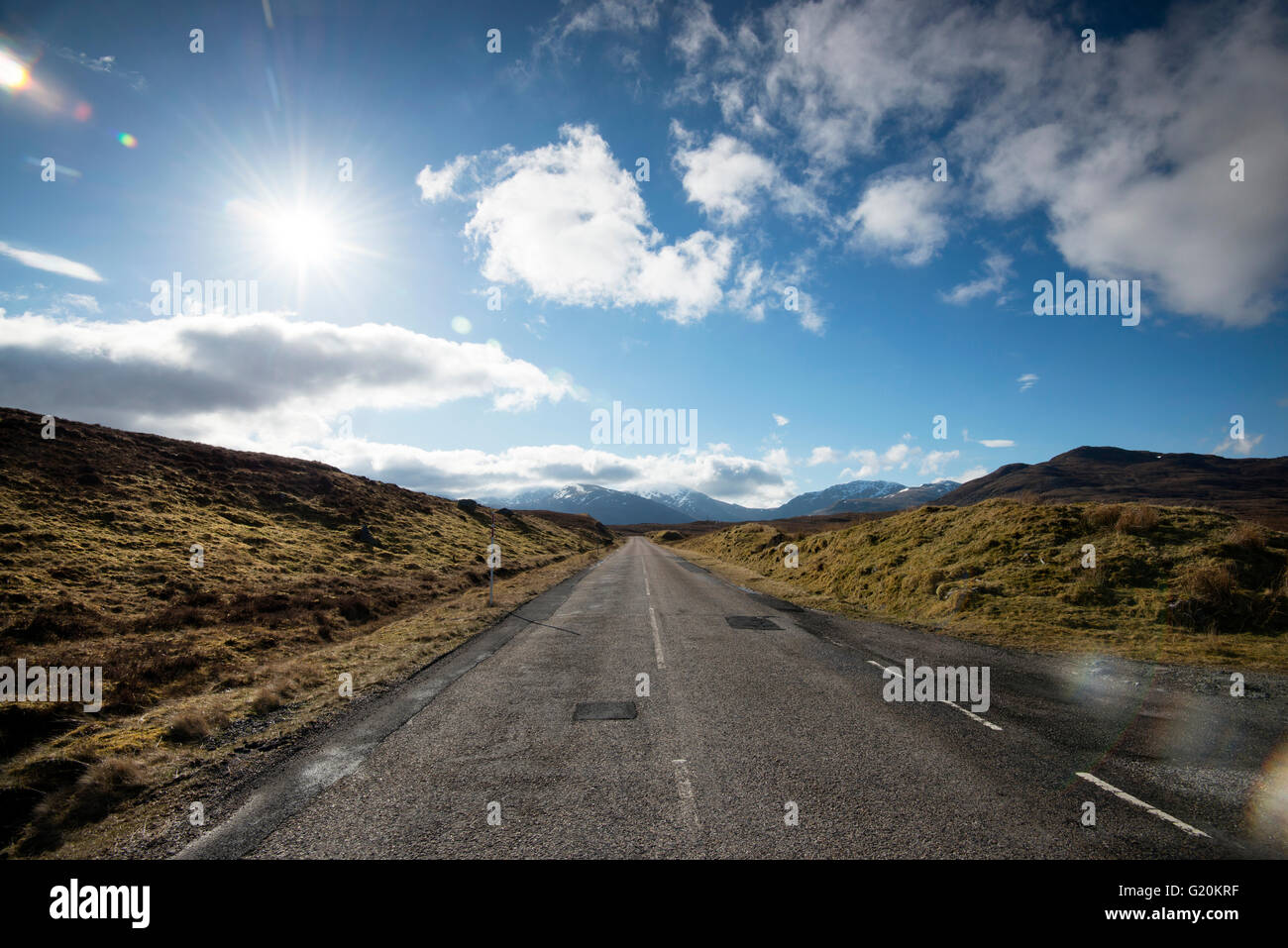 Nubes blancas mullidas e interminable camino abierto en la A832 en el extremo noroeste de Escocia, Reino Unido Foto de stock