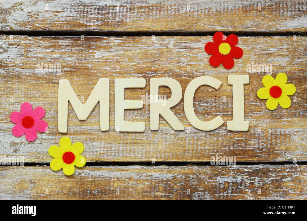 Merci (que significa gracias en francés) escrito en letras de madera sobre la superficie rústica