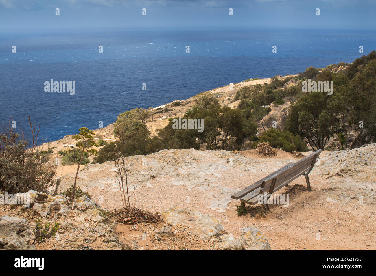 En la parte superior de los acantilados de Dingli, banco de madera con vistas panorámicas al mar. Isla del Mediterráneo, Malta. Foto de stock