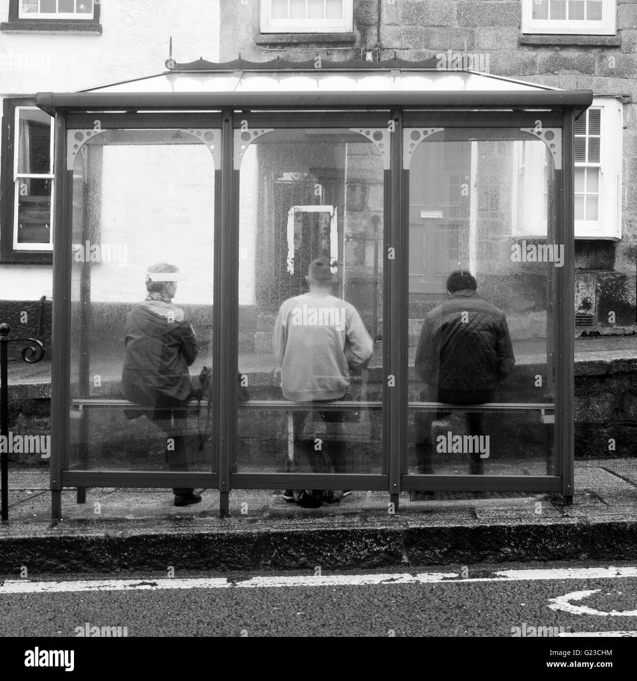 Tres personas se sentaron en Refugio autobús en Penryn, nr Falmouth, Cornwall Foto de stock