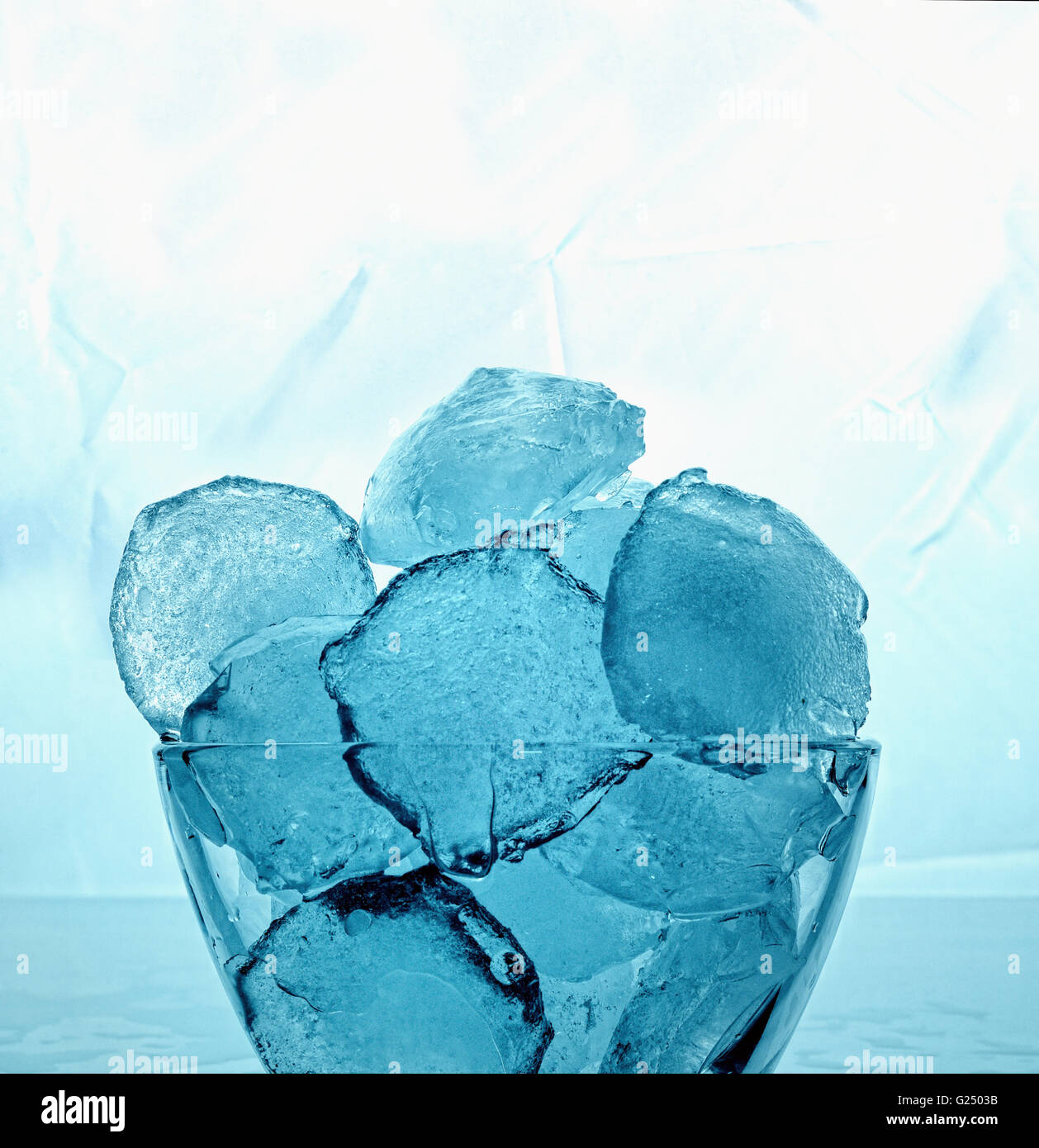 Cubitos de hielo en un recipiente de cristal en un congelador Foto de stock