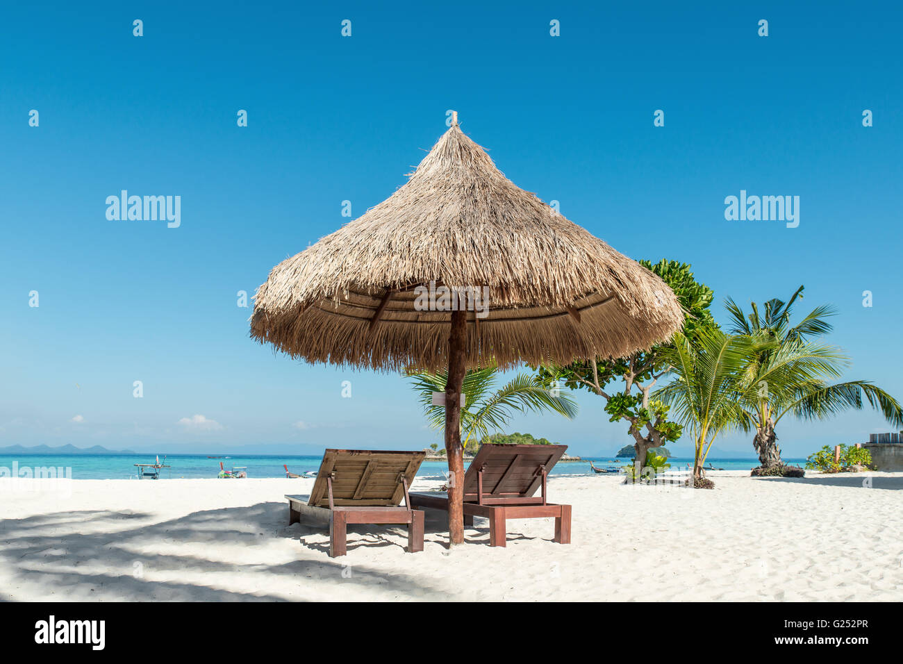 Verano, Viajes, vacaciones y días festivos - Concepto de sillas y sombrillas de playa en la isla de Phuket, Tailandia Foto de stock