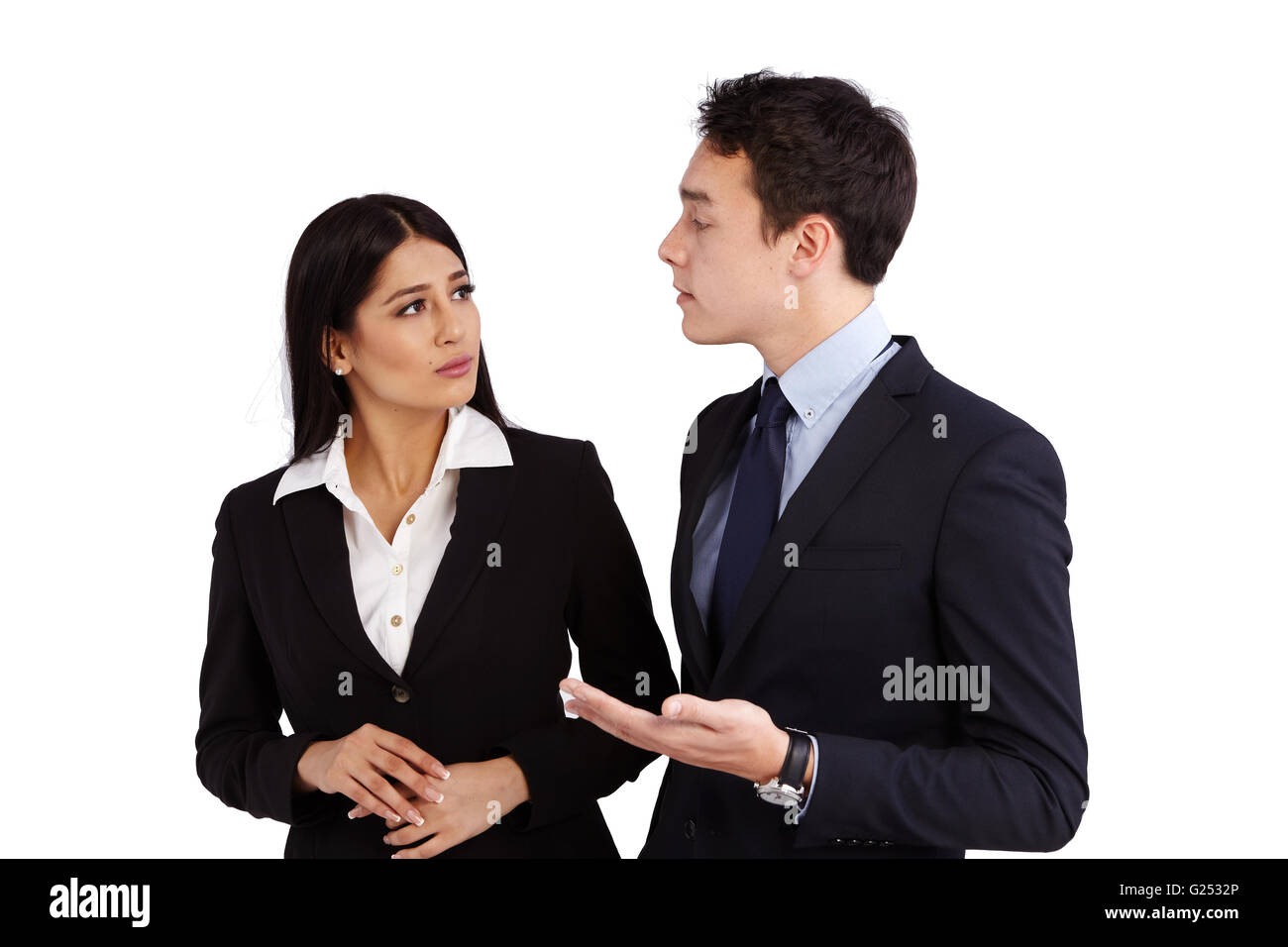 Un joven hombre de negocios del Cáucaso está hablando con una mujer de negocios con desaprobación. Ella es fruncir el ceño mientras busca en él. Foto de stock
