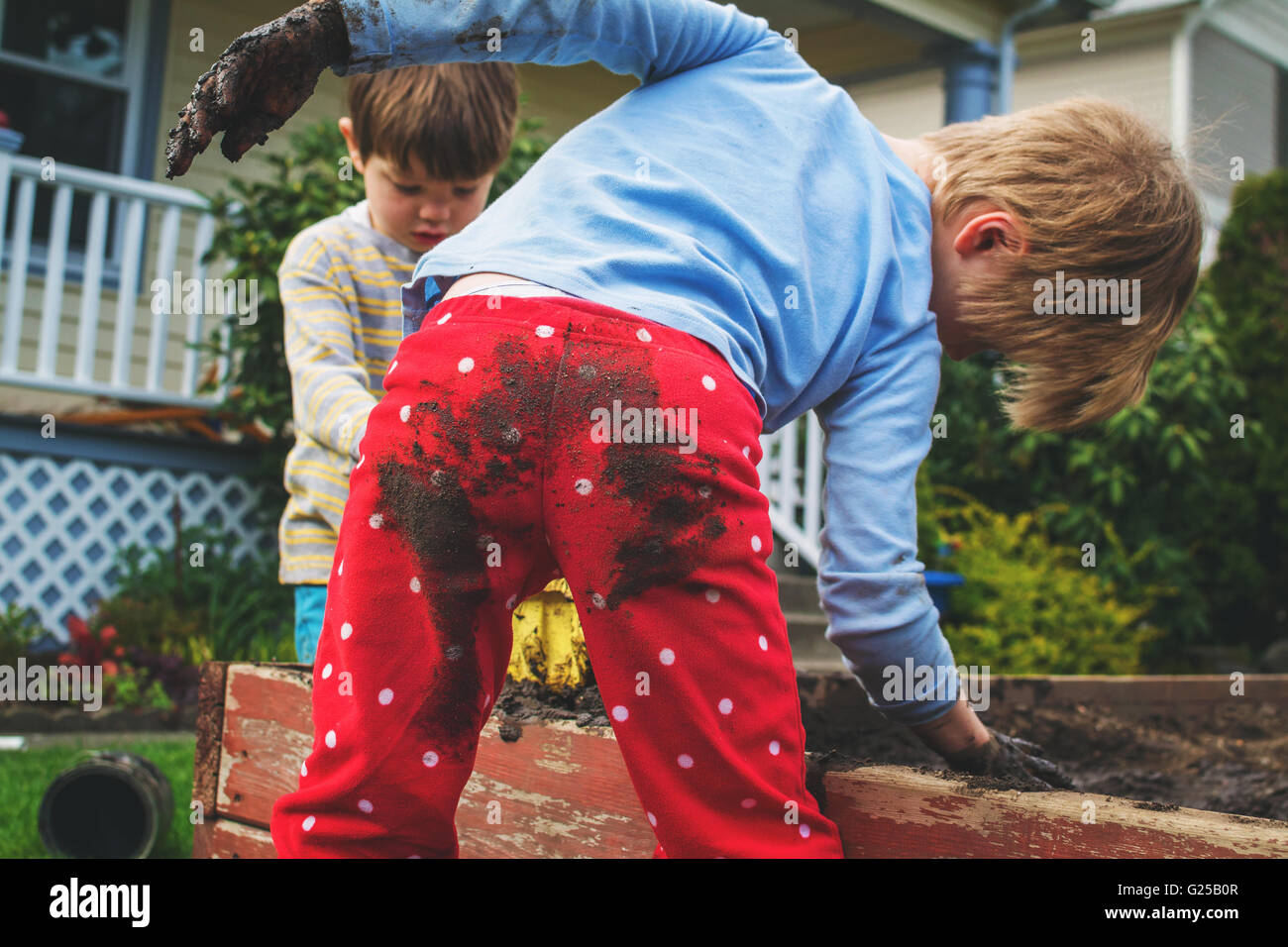 Dos muchachos cubierto de barro jardinería Foto de stock