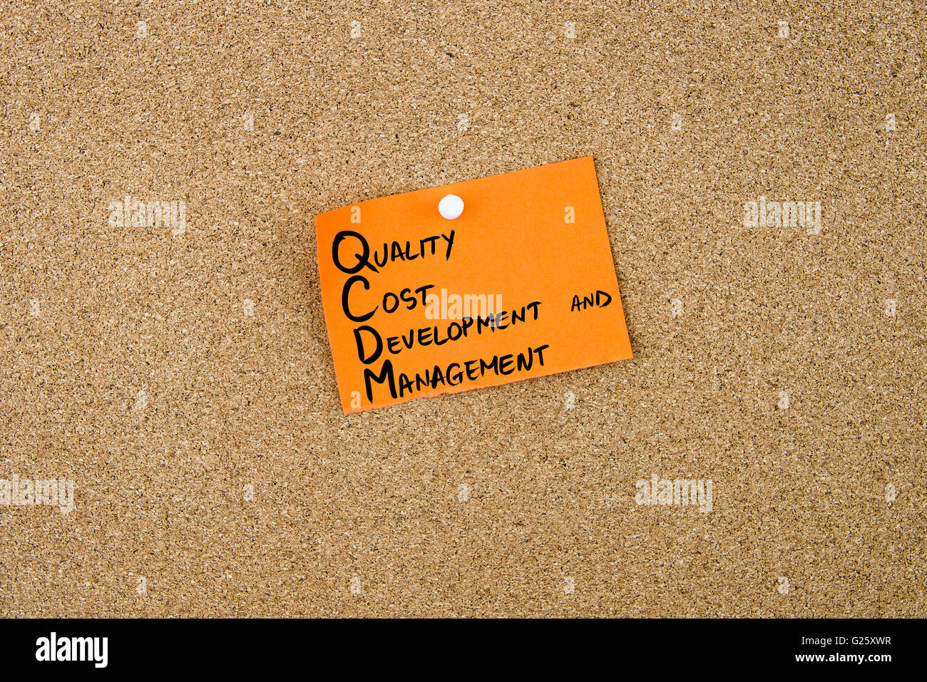 QCDM como coste de desarrollo y gestión de la calidad escrito en papel naranja nota fijada en tablero de corcho blanco con chinchetas, copie el espacio disponible Foto de stock