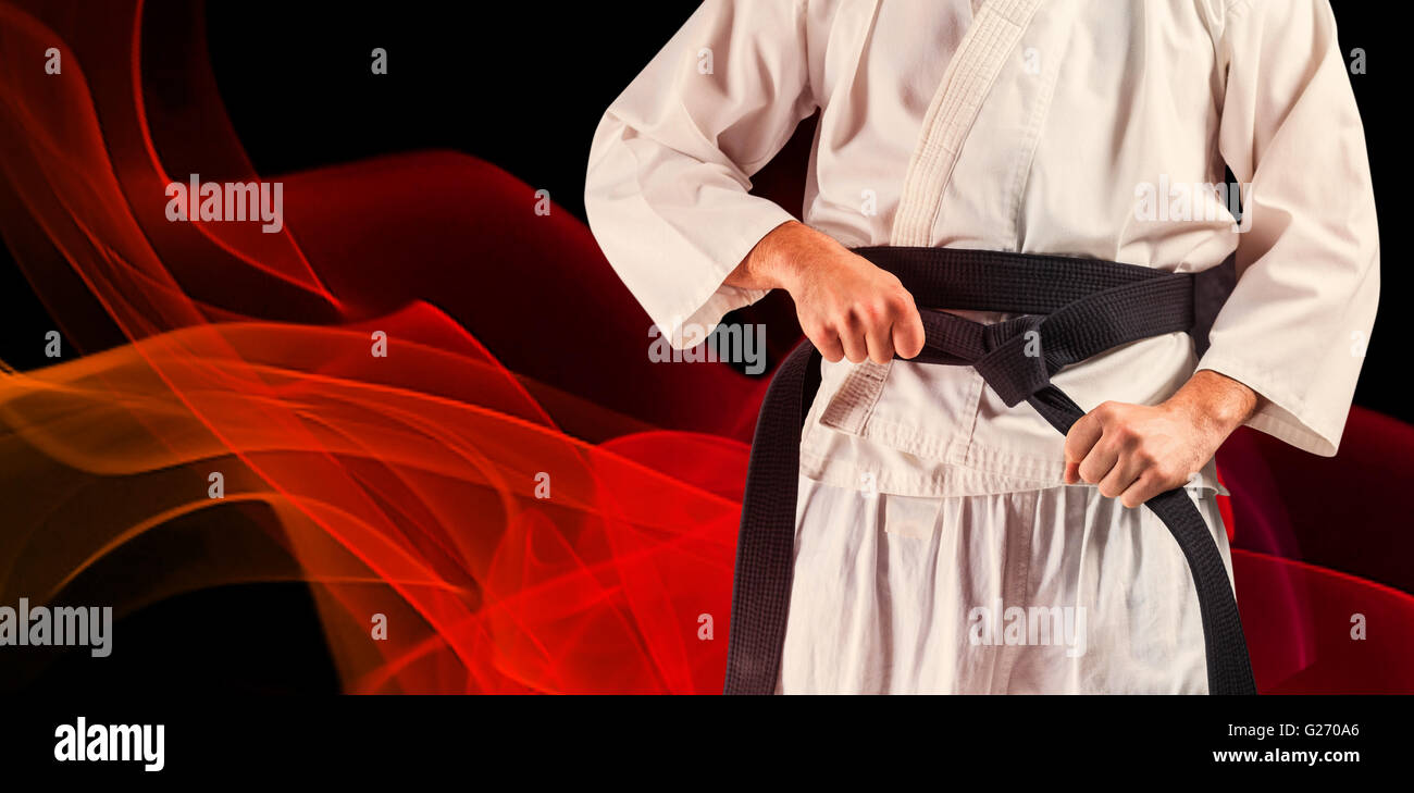 Imagen compuesta de la sección intermedia de fighter Apriete cinturón de karate Foto de stock