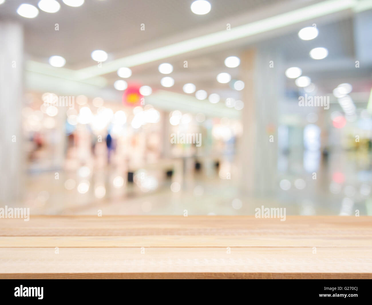 Placa de madera tabla vacía delante de fondo borroso. Perspectiva sobre madera ligera borrosidad en shopping mall - puede utilizarse para dis Foto de stock