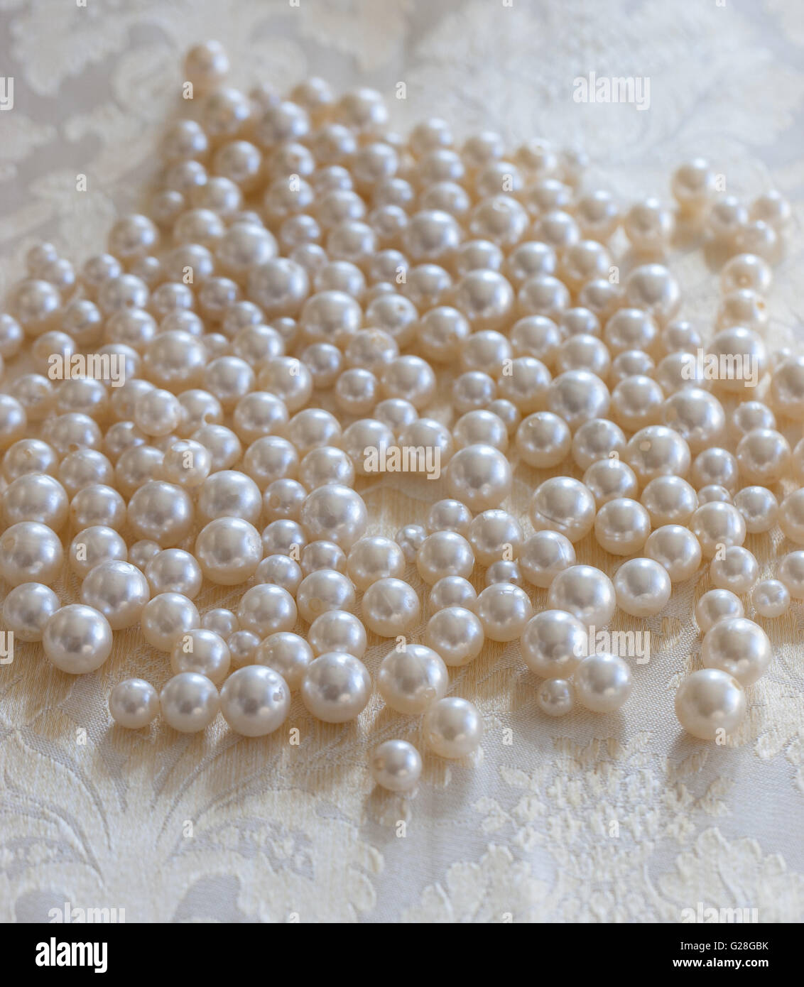 Perlas de color crema sobre un mantel brillante Fotografía de stock - Alamy