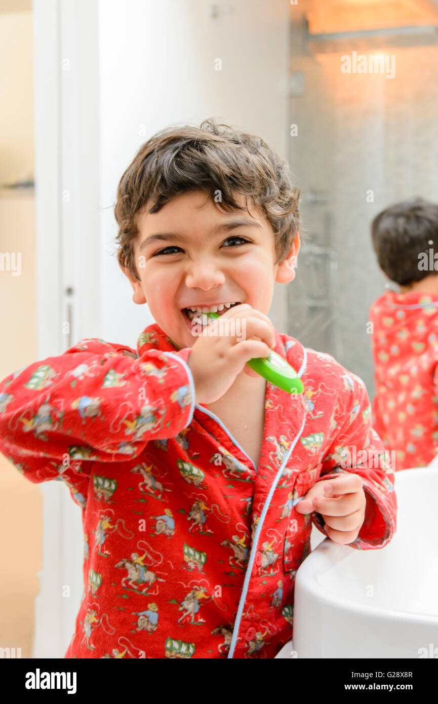 Niño cepillarse los dientes en un pijama Foto de stock