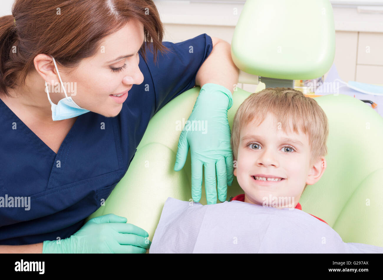 Feliz y sonriente niño al dentista sin miedo sentado en la silla de