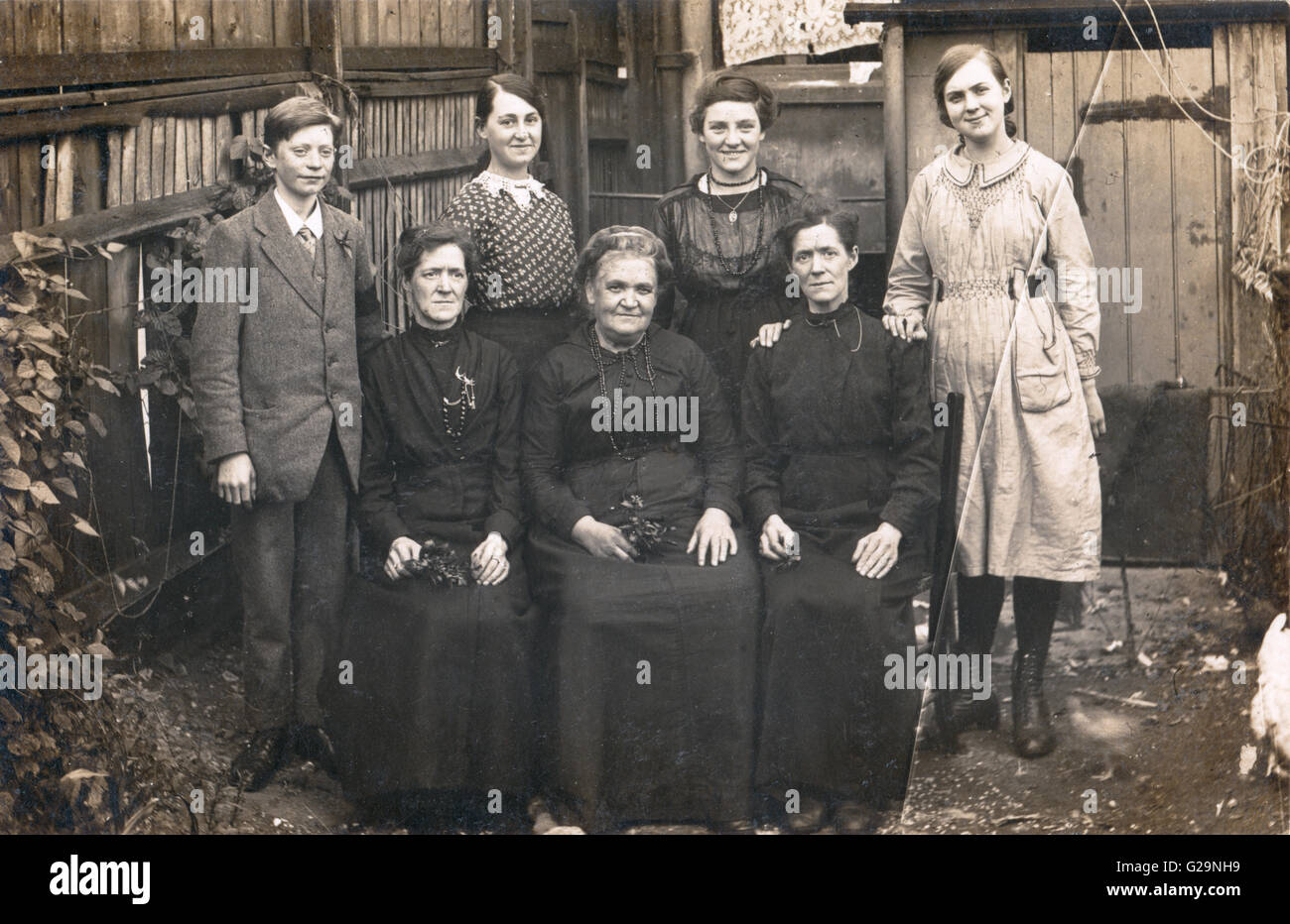 Inglaterra, 1909. Retrato de Grupo en blanco y negro en el funeral de varios miembros de una familia de jóvenes a viejos. La placa fotográfica de cristal con crack de arriba a abajo. Foto de stock