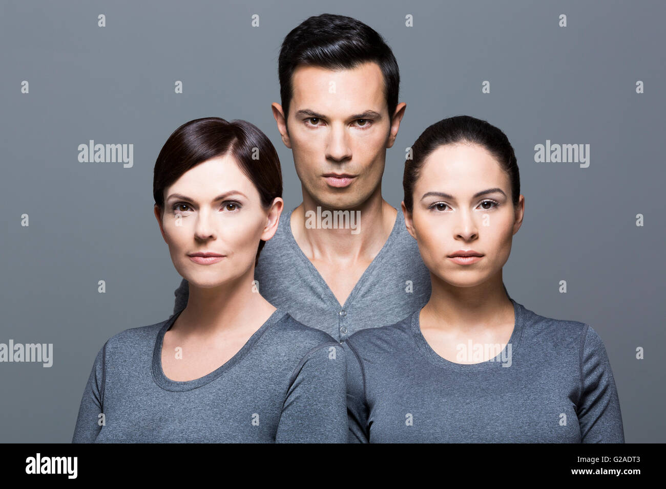 Hombre y dos mujeres que llevaban tops gris Foto de stock