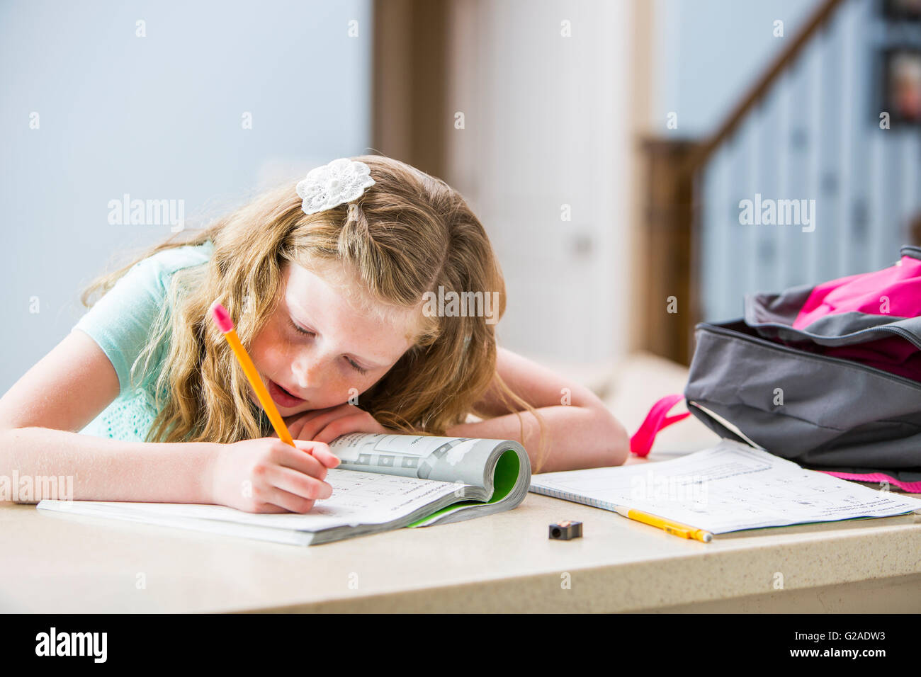 Chica (8-9) haciendo los deberes Foto de stock