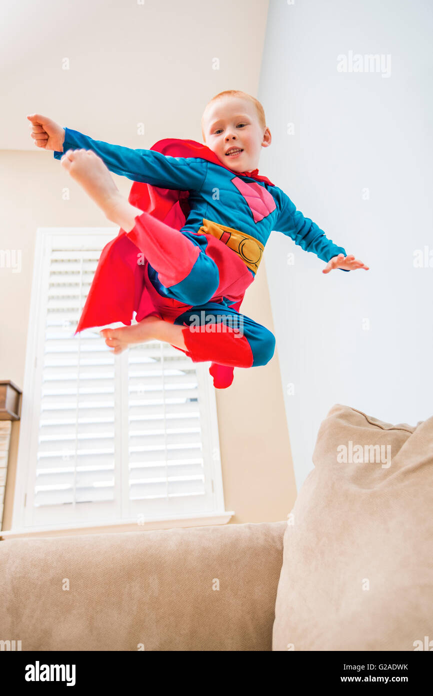 Silla Están familiarizados Melodrama Little Boy (2-3) en traje superman saltando en el sofá Fotografía de stock  - Alamy