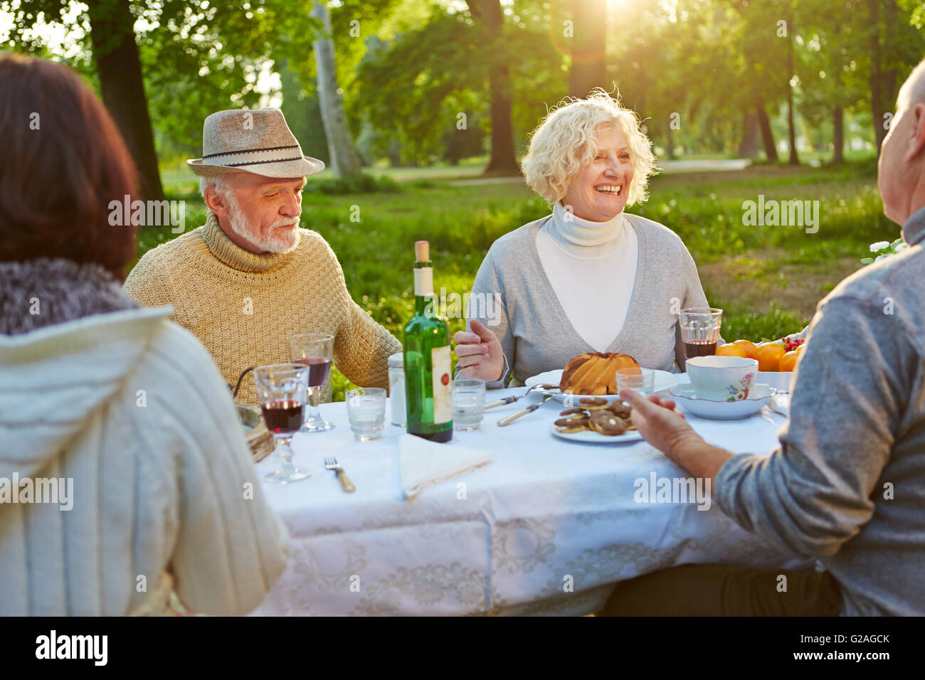 Familia Feliz con ancianos celebrando un cumpleaños en un jardín en verano Foto de stock