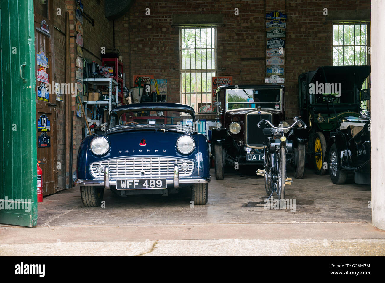 1958 Triumph TR3 y otros coches clásicos en un garaje al Centro de Patrimonio de Bicester. Oxfordshire, Inglaterra Foto de stock