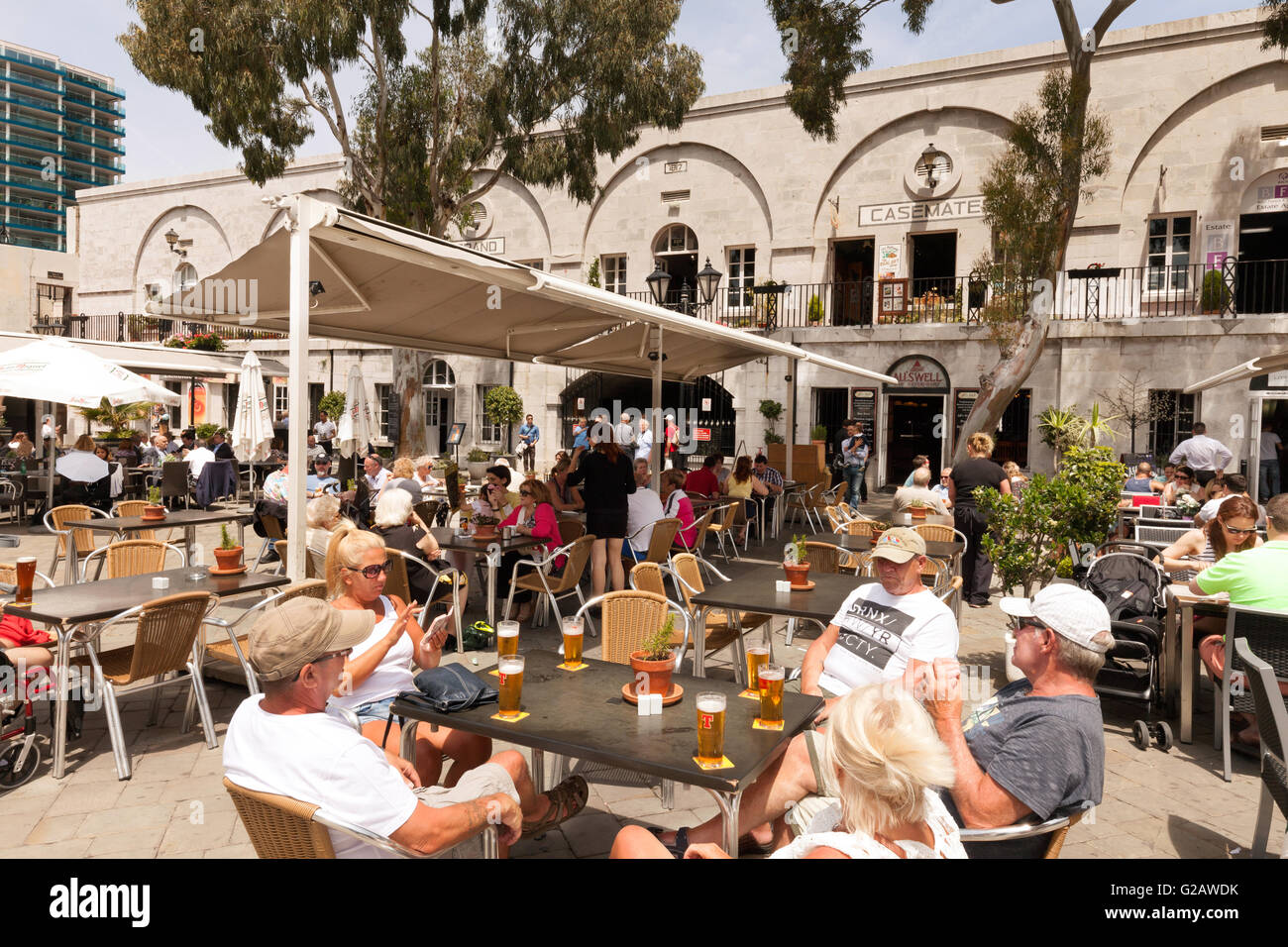 Gente bebiendo cerveza al aire libre en un café durante el día, Casemates Square, Gibraltar, Europa Foto de stock