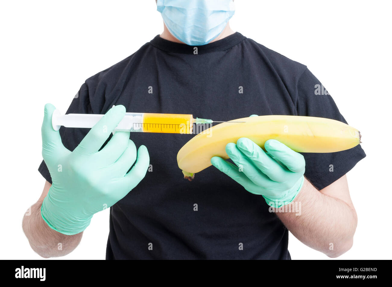 Banana genéticamente modificados o fruta y jeringa en manos varón vestido de azul guantes como alimento artificial concepto aislado en blanco Foto de stock