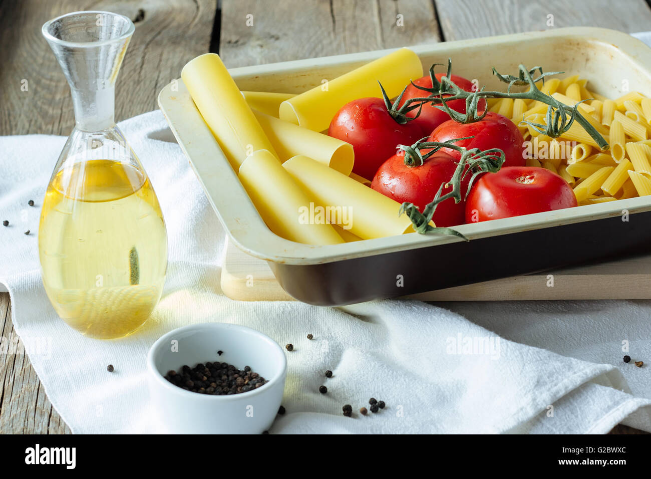 Pasta, tomates, aceite de oliva crudo enfoque selectivo Foto de stock