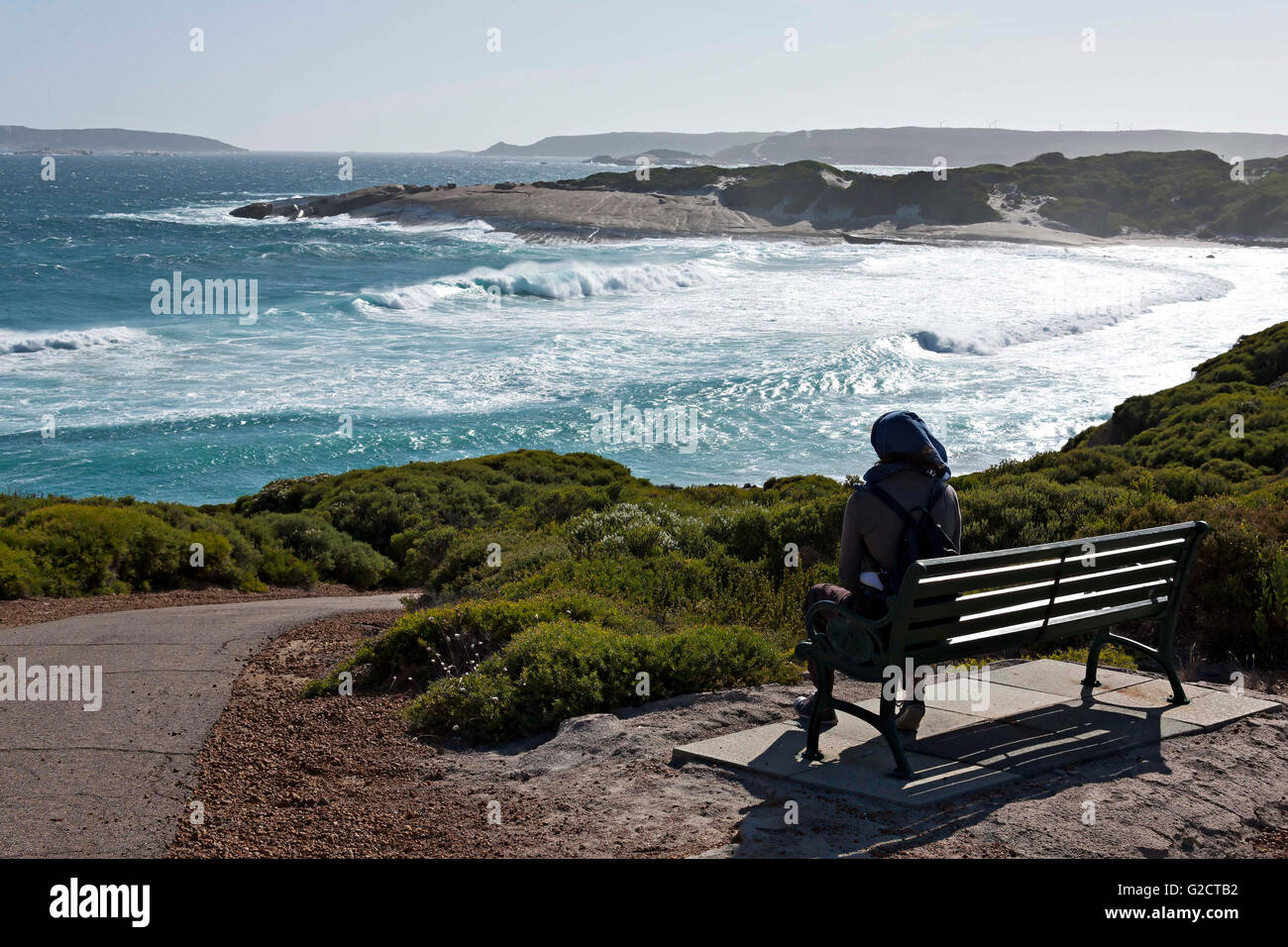 Una mujer sentada sobre una banqueta mirando a lo largo de la costa de Australia Occidental, el Esperance Foto de stock