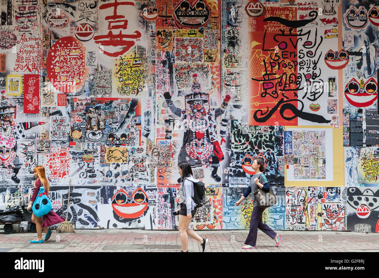 Hong Kong, gran mural, el arte público de caligrafía e imágenes en una calle transitada, un típico paisaje urbano, graffiti muro cubierto Foto de stock