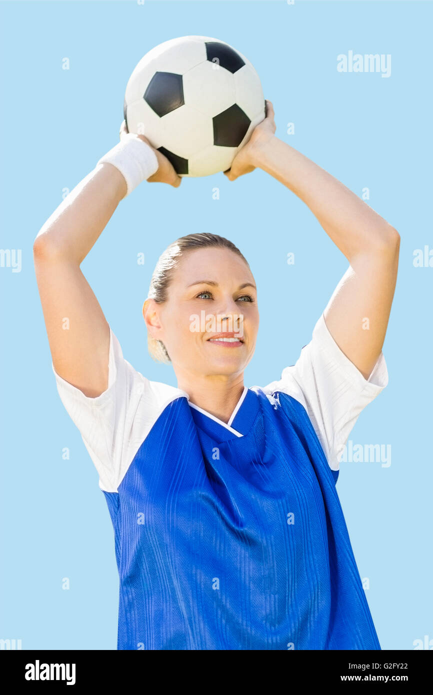 Imagen compuesta de mujer sosteniendo un balón del jugador de fútbol Foto de stock