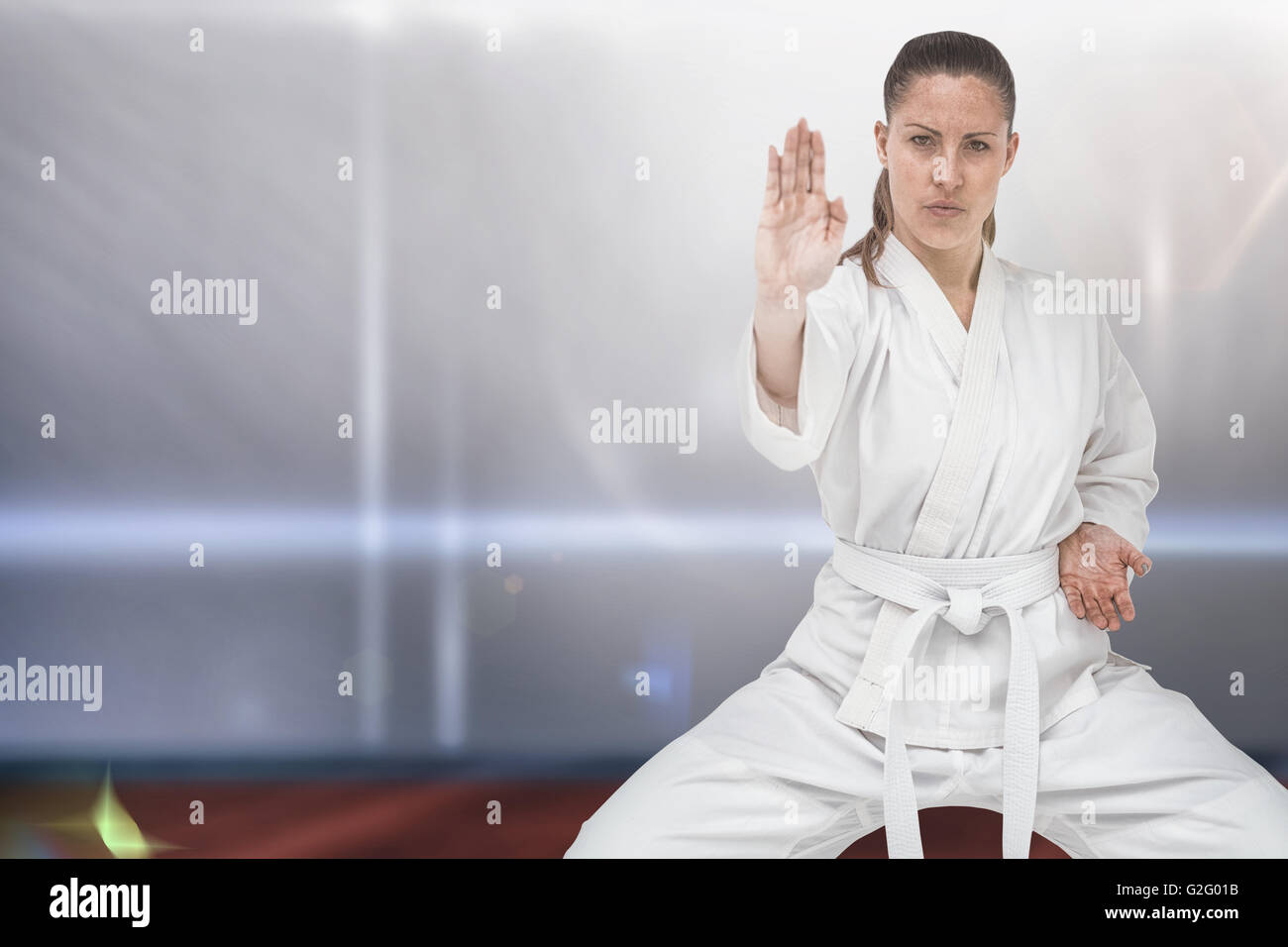 Imagen compuesta de combatiente femenino postura realizar karate Foto de stock