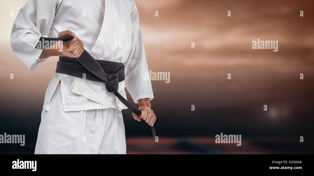 Imagen compuesta de la sección intermedia de fighter Apriete cinturón de karate Foto de stock