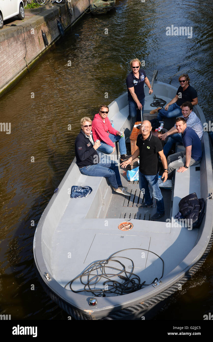 Los adultos jóvenes riendo steer canal abierto pequeño barco buscar reír plantean la foto. Foto de stock