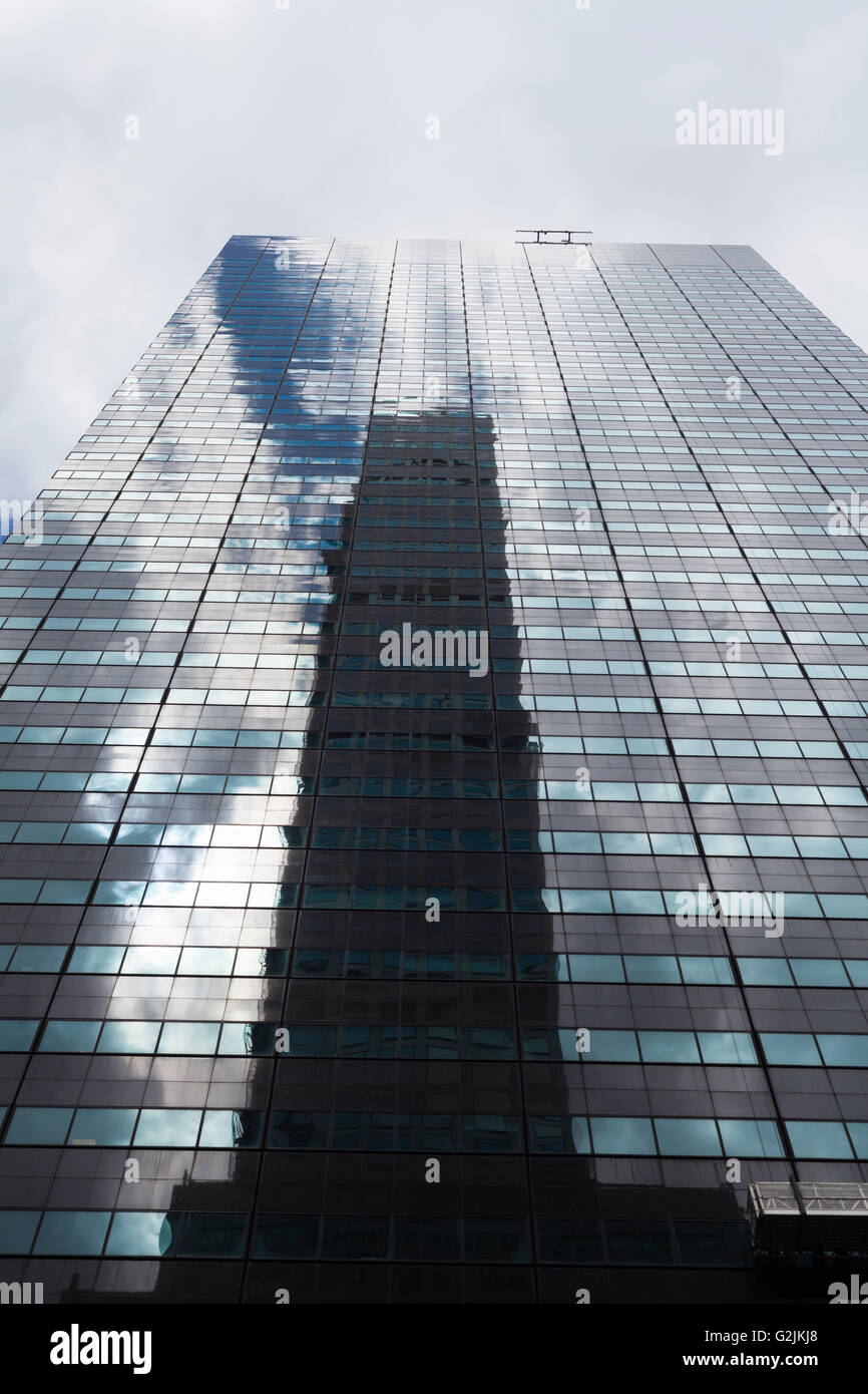 Ángulo de visión baja de un rascacielos con ventanas de vidrio y reflexiones en Manhattan, Ciudad de Nueva York. Foto de stock