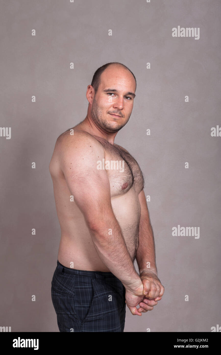 Retrato del hombre descamisado posando y mostrando sus tríceps y robusto cuerpo. Foto de stock