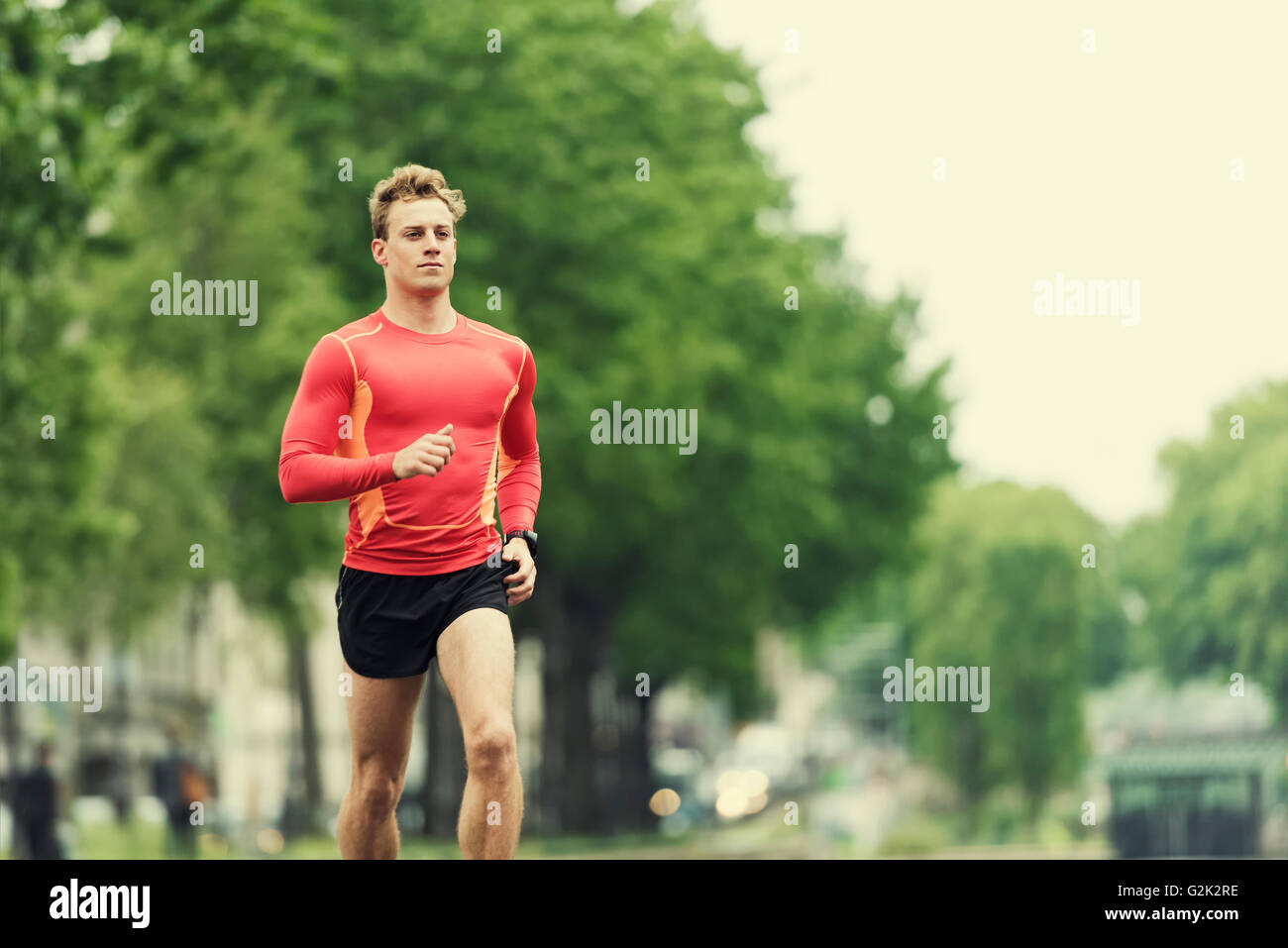 Joven hombre corriendo en la ciudad. Emparejador Cheerfull caucásica macho en su 20s Foto de stock